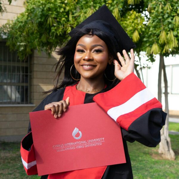 a woman in a graduation cap and gown holding a piece of paper